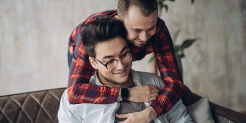 Man surprising his boyfriend with a present, popping the question while visiting his friend s home. Happy Birthday Gift, Present, Surprise Concept.